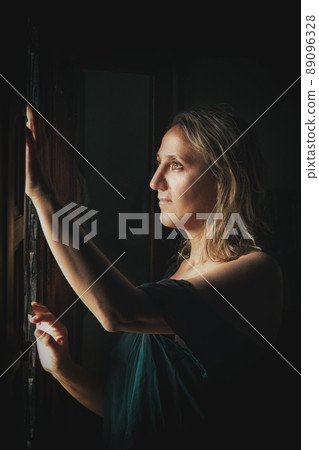 a young woman stands at the window a young woman stands at the window 89096328