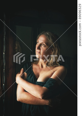 a young woman stands at the window a young woman stands at the window 89096329