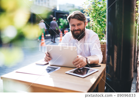 Positive businessman using laptop while working remotely 89096833