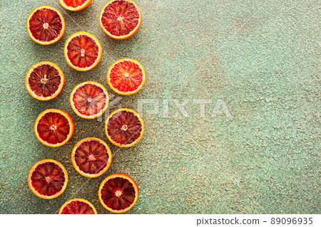 Blood orange halves on a green background 89096935