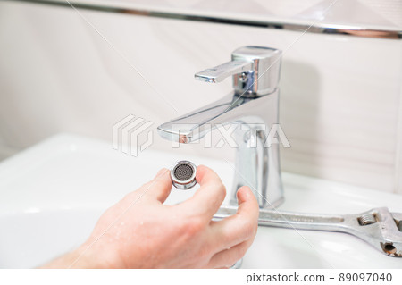 the repairman removes and cleans the Aerator from water stone and rust.  89097040