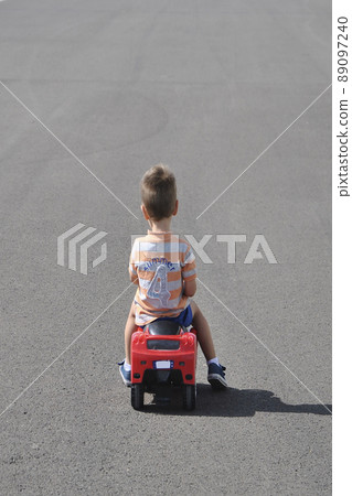 Boy in striped shirt playing with toy car 89097240