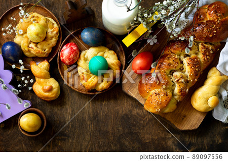 Easter holiday table. Easter cakes and colored eggs on a wooden table. Top view flat lay background. Copy space. Easter holiday table. Easter cakes and colored eggs on a wooden table. Top view flat lay background. Copy space. 89097556