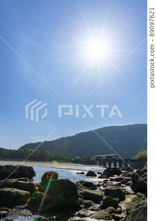 JR九州地方線日南線Kiha 40在宮崎縣日南市山王的熊谷川橋上行駛，在日南海岸上鋪滿湛藍的天空 89097621