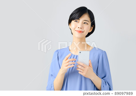 Bust up of business woman who operates smartphone 89097989