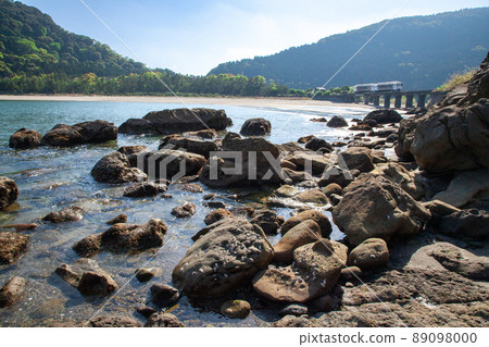 JR Kyushu Nichinan Line Local Limited Express Umisachi Yamasachi running on the Kumagaya River Bridge in Sanno, Nichinan City, Miyazaki Prefecture, where the clear blue sky spreads on the Nichinan coast 89098000