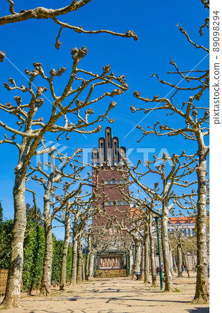 Weddingtower, Mathildenhoehe Darmstadt, behind trees against blue sky 89098294