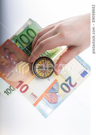 Hand holding compass  on Euro banknotes as business,  finance concept 89098682