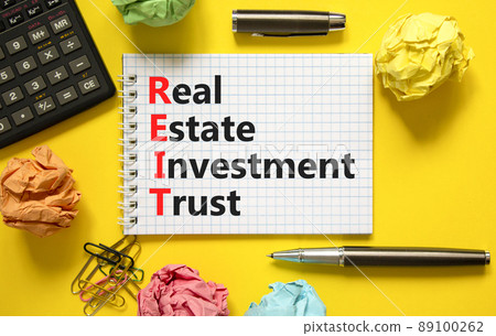 REIT real estate investment trust symbol. Concept words REIT real estate investment trust on note on beautiful yellow background. Black calculator. Business REIT real estate investment trust concept. 89100262