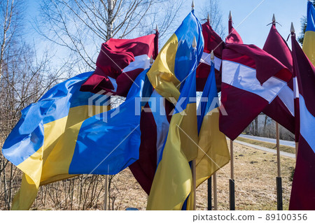 Flags of Ukraine and Latvia. Protest against war and global military conflict, invasion in Riga, Europe. 89100356