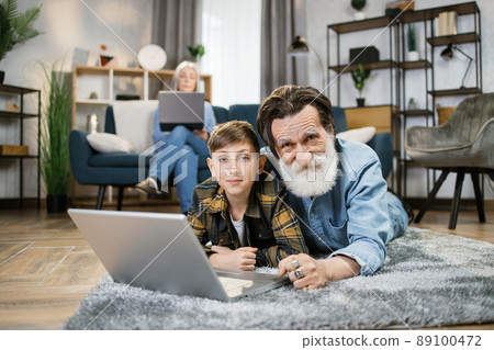 Grandparents and grandchild relax at home. Grandparents and grandchild relax at home. 89100472