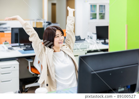 Young woman stretching in the office Young woman stretching in the office 89100527