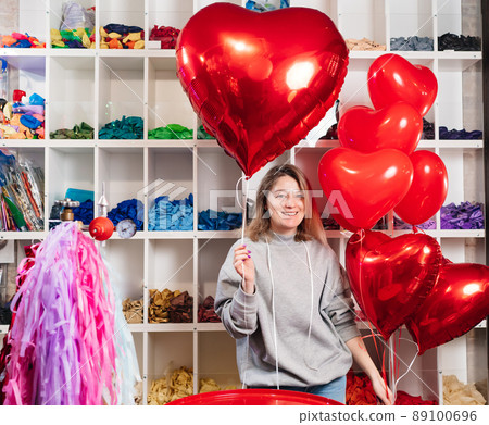 woman with a large red ball of foil in the shape of heart. 89100696