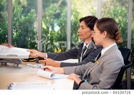 Aviation workers are discussing how to work at ground work. 89100726