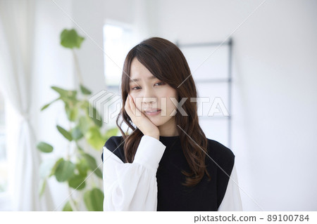 A woman who has a toothache and holds her cheeks A woman who has a toothache and holds her cheeks 89100784
