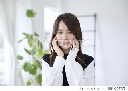 A woman who has a toothache and holds her cheeks A woman who has a toothache and holds her cheeks 89100785