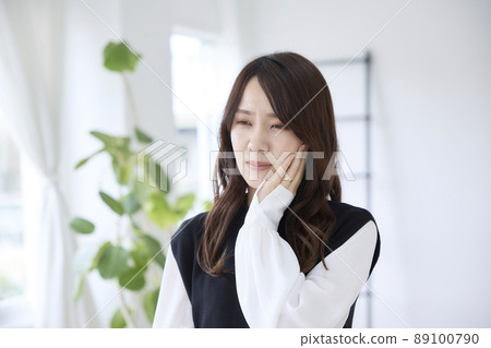 A woman who has a toothache and holds her cheeks A woman who has a toothache and holds her cheeks 89100790