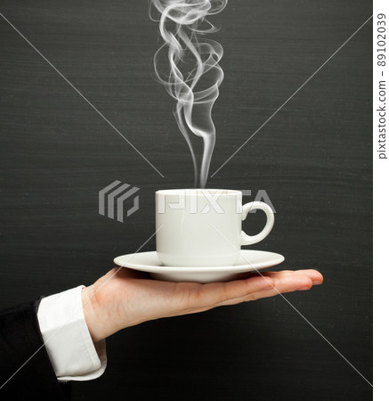 hand holding a cup with hot coffee hand holding a cup with hot coffee 89102039