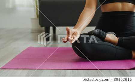 Attractive wellness Asian young woman sit on carpet breathing with yoga lotus pose, Yoga Exercise for Wellness Concept, Close up shot. Attractive wellness Asian young woman sit on carpet breathing with yoga lotus pose, Yoga Exercise for Wellness Concept, Close up shot. 89102916