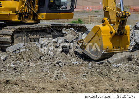 Heavy machinery removing buried objects at a civil engineering site 89104173