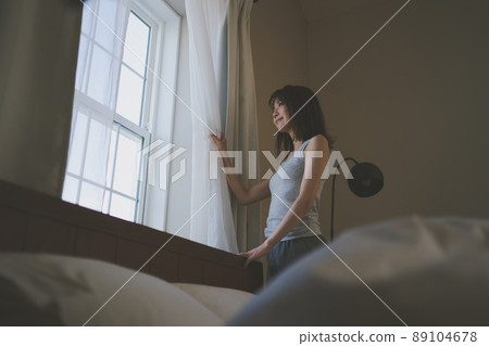 Woman looking out the window in the morning Woman looking out the window in the morning 89104678