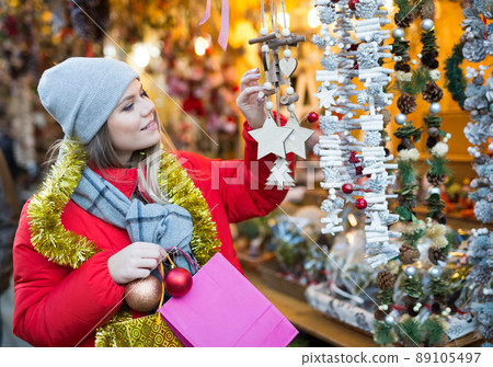 Positive smiling woman at fair near counter with Christmas gifts 89105497