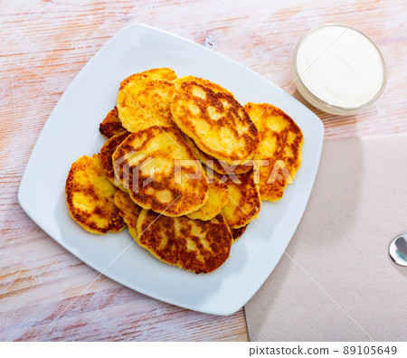 Tasty cheesecakes with sour cream on a plate Tasty cheesecakes with sour cream on a plate 89105649