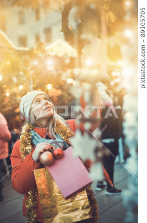 Girl shopping Christmas decorations 89105705