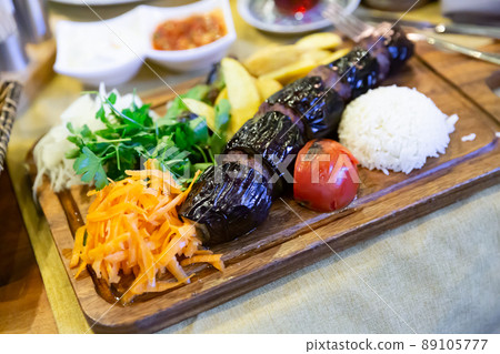 Turkish eggplant kebab with minced meat with vegetables and rice Turkish eggplant kebab with minced meat with vegetables and rice 89105777
