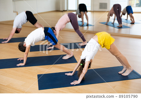 Family of four practicing yoga at gym Family of four practicing yoga at gym 89105790