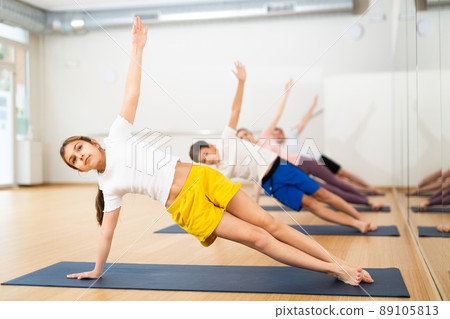 Girl practicing yoga at studio with family 89105813