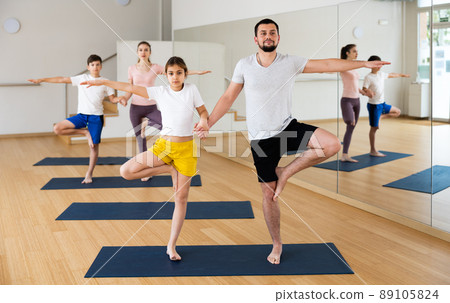 Family practicing yoga in pairs at gym Family practicing yoga in pairs at gym 89105824