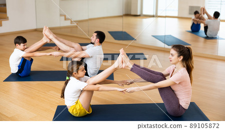 Teen girl doing yoga in pair with mom in studio Teen girl doing yoga in pair with mom in studio 89105872
