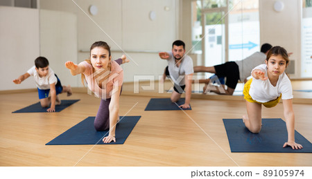 Kids and parents doing bird dog exercise in gym Kids and parents doing bird dog exercise in gym 89105974