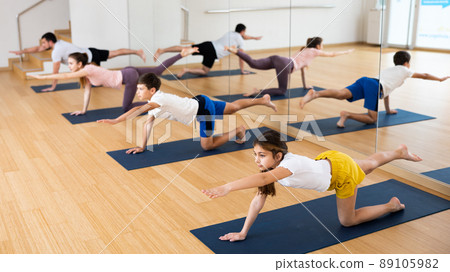 Kids and parents doing bird dog exercise in gym Kids and parents doing bird dog exercise in gym 89105982