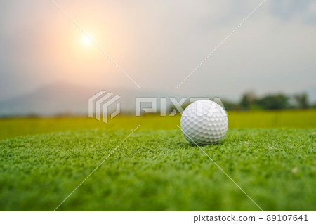 Golf ball on the green with warm tone and sunset. Golf ball on Green field golf course in morning time with soft sunlight. Golf ball on the green with warm tone and sunset. Golf ball on Green field golf course in morning time with soft sunlight. 89107641