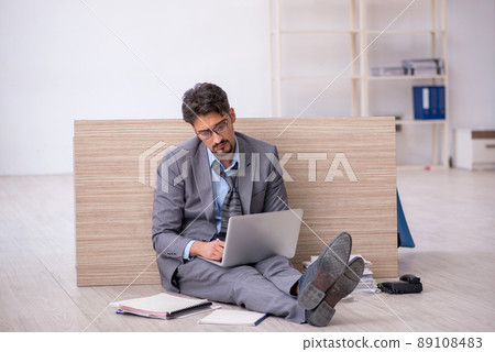 Young male employee working overtime in the office Young male employee working overtime in the office 89108483