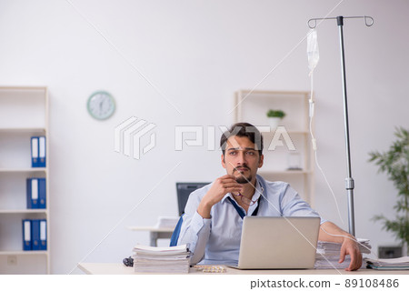 Young male employee suffering at workplace Young male employee suffering at workplace 89108486