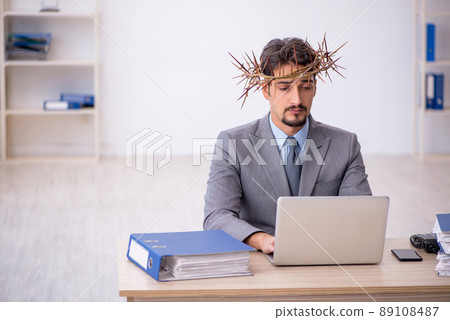 Young male employee wearing prickly wreath on head Young male employee wearing prickly wreath on head 89108487