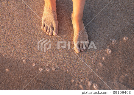 Beach - women's foot and the grains of sand. 89109408