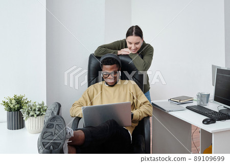 Two happy young multiracial software developers looking at laptop screen 89109699