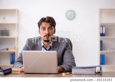 Young male employee sitting in the office Young male employee sitting in the office 89110165