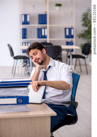 Young male employee unhappy with excessive work in the office 89110166