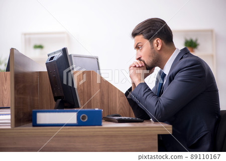 Young male employee working in the office 89110167