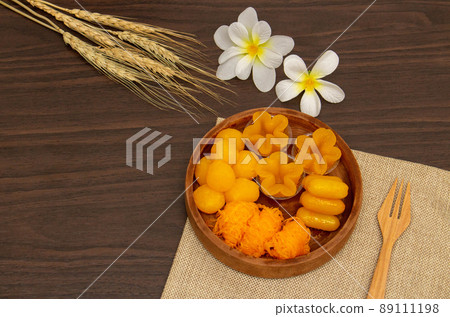 Thai traditional dessert concept, Thong Yip Thong Yod Foi Thong and jackfruit seeds in wood bowl Thai traditional dessert concept, Thong Yip Thong Yod Foi Thong and jackfruit seeds in wood bowl 89111198