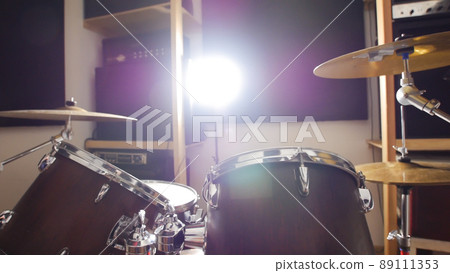 Drum set in a dark studio, lit by a lamp 89111353