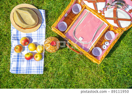 Green lawn with pic nic concept. Set of glasses and plates 89111950