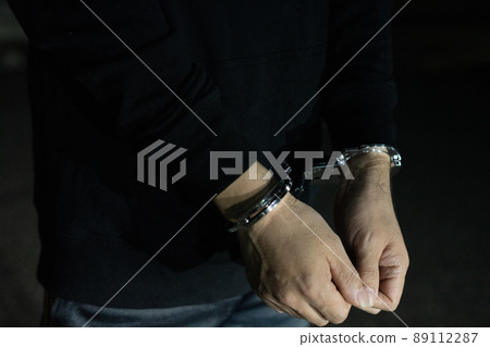 Handcuffed man's arm Handcuffed man's arm 89112287