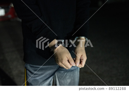 Handcuffed man's arm Handcuffed man's arm 89112288