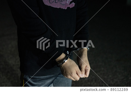 Handcuffed man's arm Handcuffed man's arm 89112289